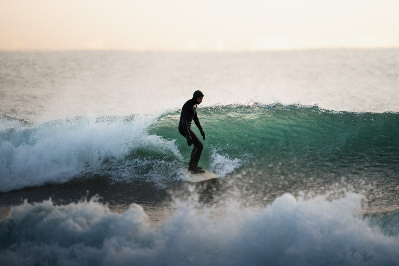 Arctic surfer riding a wave in Iceland