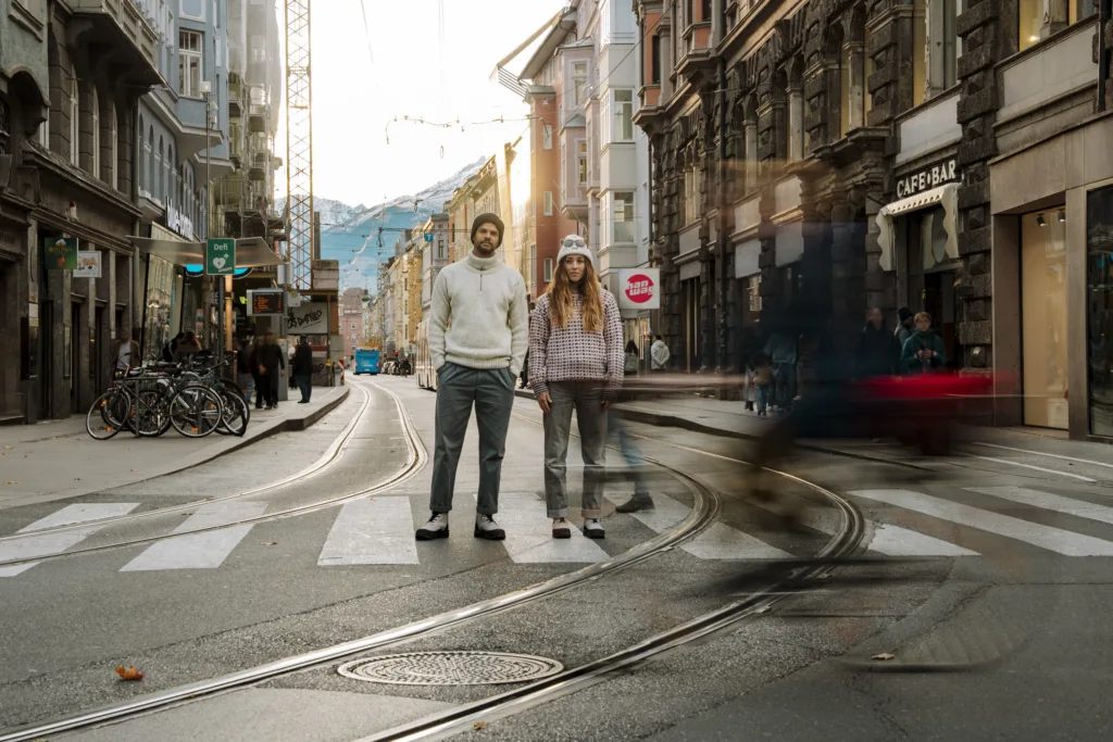 Male and Female standing in de streets wearing the Hanwag Anvik GTX. It is photographed with slow shutter to drag lines of moving elements in the frame.